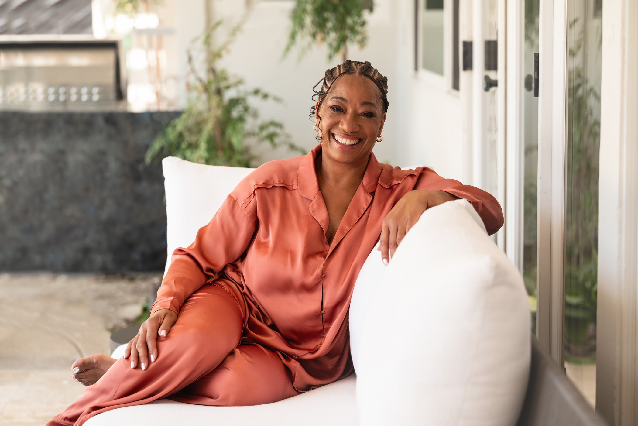 Lisane lounging on a sofa, mid-laugh